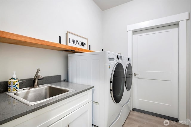 7420 Windsong Ln, Sedro Woolley, WA 98284 - washroom with washer and dryer, light wood-type flooring, and cabinet space