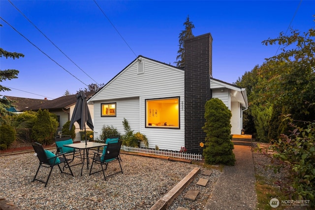 8535 16th Ave NW, Seattle, WA 98117 - back of house at dusk featuring a chimney, a patio, and outdoor dining space