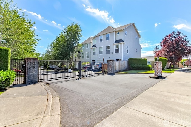 2311 Milton Way Unit F, Milton, WA 98354 - view of asphalt road featuring a gate, sidewalks, a gated entry, and curbs