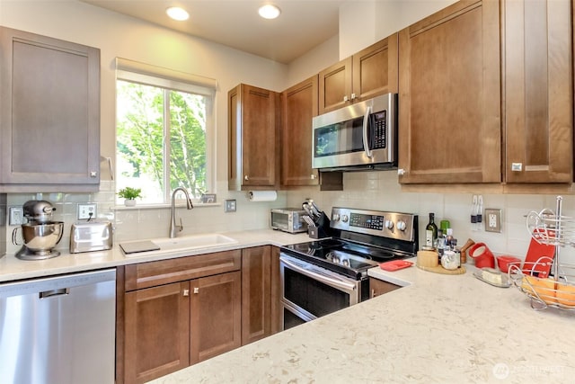2311 Milton Way Unit F, Milton, WA 98354 - kitchen featuring stainless steel appliances, a sink, tasteful backsplash, brown cabinetry, and recessed lighting
