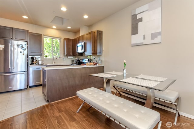 2311 Milton Way Unit F, Milton, WA 98354 - kitchen with stainless steel appliances, a sink, a peninsula, light countertops, and light wood-style floors