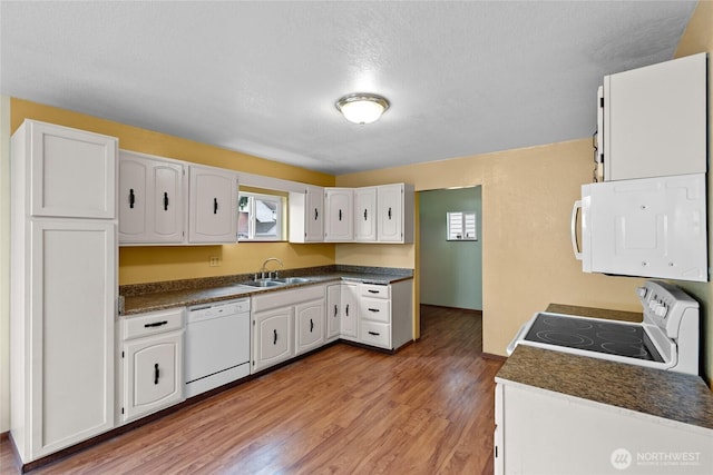 1428 N 2nd Ave, Kelso, WA 98626 - kitchen with white appliances, a sink, dark countertops, white cabinets, and light wood-type flooring