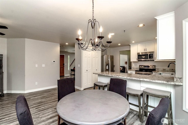 11608 SE 228th Pl, Kent, WA 98031 - kitchen featuring stainless steel appliances, a sink, a peninsula, light stone countertops, and white cabinetry