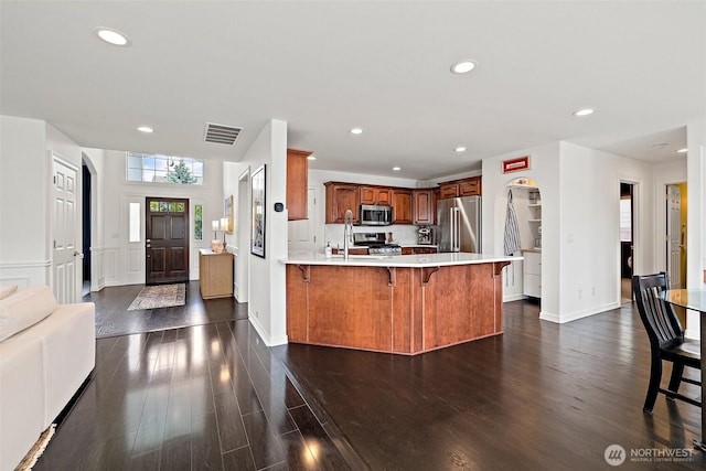 30101 129th Pl SE, Auburn, WA 98092 - kitchen featuring stainless steel appliances, a peninsula, a breakfast bar area, dark wood-style flooring, and recessed lighting