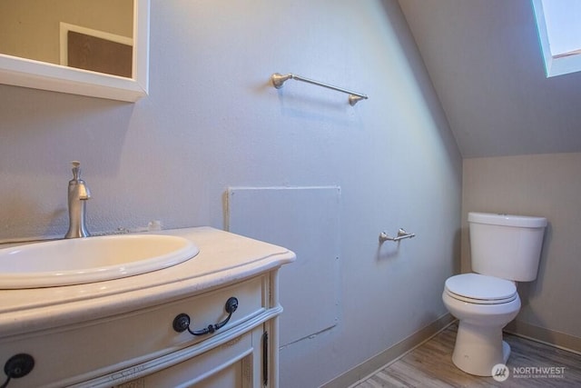 517 S Hartford Ave, Bremerton, WA 98312 - bathroom featuring toilet, vanity, vaulted ceiling, wood finished floors, and baseboards