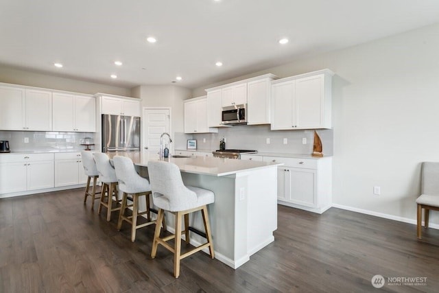 1134 Baker Heights Loop, Bremerton, WA 98312 - kitchen featuring stainless steel appliances, a sink, backsplash, an island with sink, and a kitchen bar