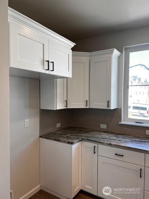 12084 126th Avenue Ct E Unit 72, Puyallup, WA 98374 - kitchen with tasteful backsplash, white cabinets, baseboards, and dark stone counters