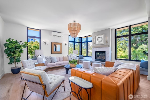 8004 39th Ave SW, Seattle, WA 98136 - living room with a wall unit AC, light wood-type flooring, a chandelier, expansive windows, and a fireplace