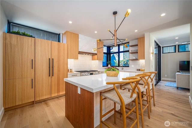 8004 39th Ave SW, Seattle, WA 98136 - kitchen featuring backsplash, a center island, range, light countertops, and light wood-style flooring