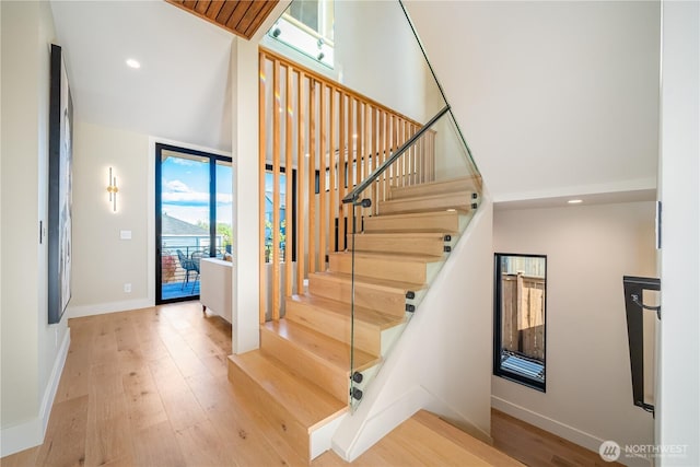 8004 39th Ave SW, Seattle, WA 98136 - stairs featuring wood finished floors, a towering ceiling, baseboards, and recessed lighting