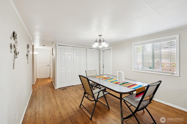 4248 A St SE Unit 518, Auburn, WA 98002 - dining space featuring light wood-type flooring, baseboards, a chandelier, and crown molding