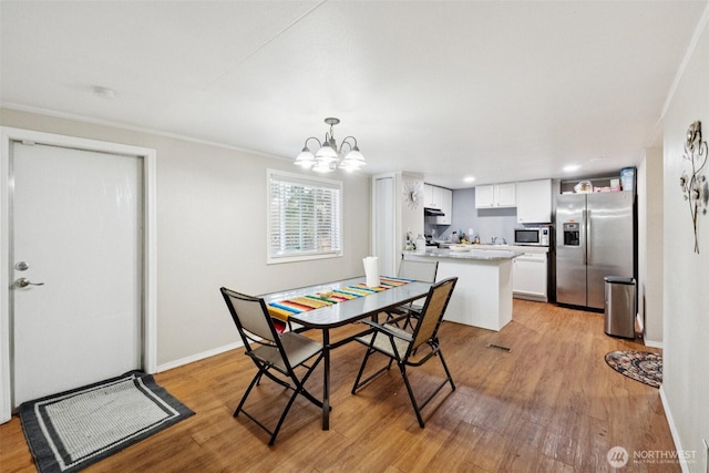 4248 A St SE Unit 518, Auburn, WA 98002 - dining area with a chandelier, light wood finished floors, and baseboards