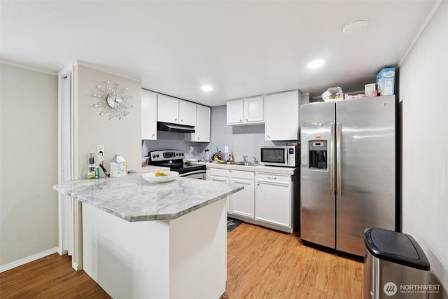 4248 A St SE Unit 518, Auburn, WA 98002 - kitchen featuring appliances with stainless steel finishes, a peninsula, under cabinet range hood, light wood-style floors, and light countertops