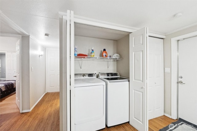 4248 A St SE Unit 518, Auburn, WA 98002 - laundry area featuring washing machine and clothes dryer, light wood-style floors, and baseboards