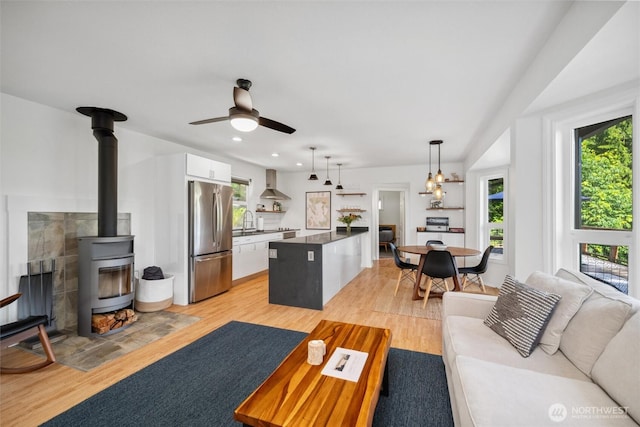 1188 Island Dr, Lummi Island, WA 98262 - living room featuring plenty of natural light, light wood-style flooring, a wood stove, ceiling fan, and recessed lighting