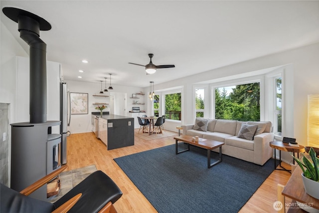 1188 Island Dr, Lummi Island, WA 98262 - living room featuring light wood-style floors, ceiling fan, a wood stove, and recessed lighting