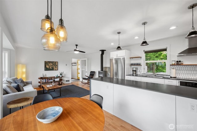 1188 Island Dr, Lummi Island, WA 98262 - dining room featuring light wood finished floors, a wood stove, a ceiling fan, and recessed lighting