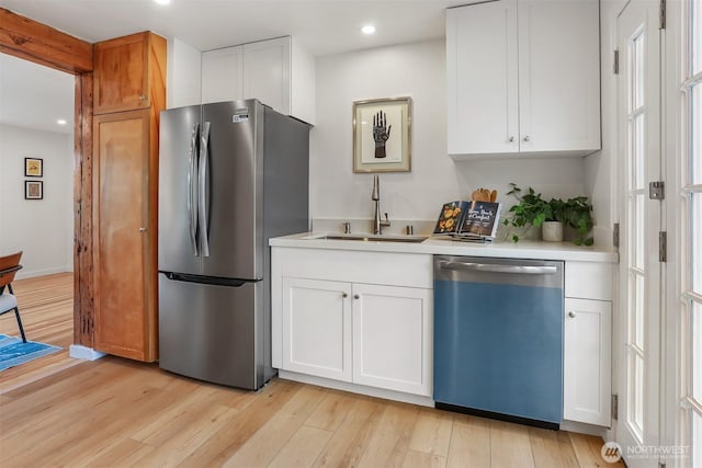 369 NW 49th St, Seattle, WA 98107 - kitchen featuring dishwashing machine, freestanding refrigerator, a sink, light countertops, and white cabinetry