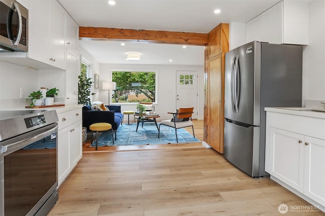 369 NW 49th St, Seattle, WA 98107 - kitchen featuring appliances with stainless steel finishes, healthy amount of natural light, light wood-type flooring, recessed lighting, and light countertops