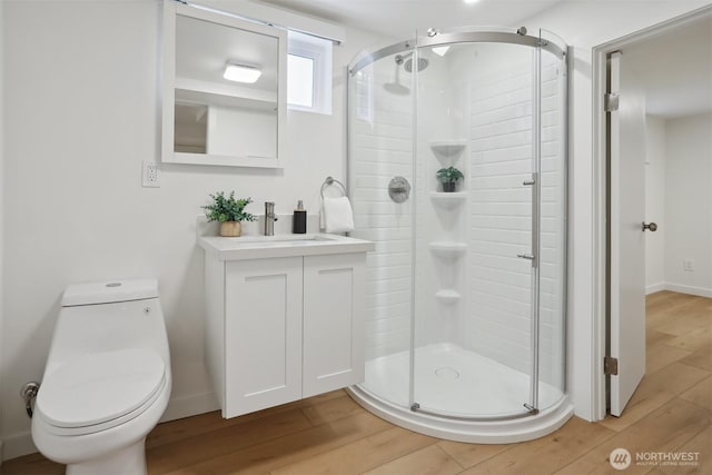 369 NW 49th St, Seattle, WA 98107 - bathroom with a stall shower, wood finished floors, vanity, toilet, and baseboards