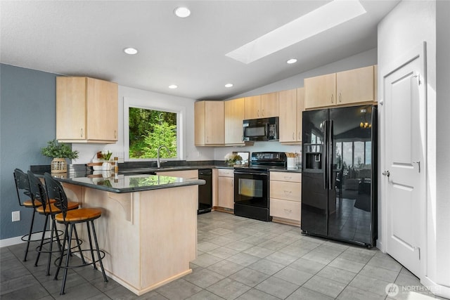 573 Klamath Dr, La Conner, WA 98257 - kitchen with black appliances, light brown cabinetry, a skylight, recessed lighting, and vaulted ceiling