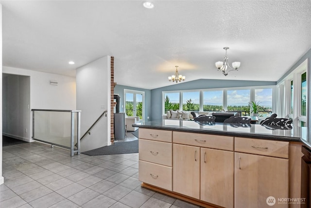 573 Klamath Dr, La Conner, WA 98257 - kitchen with a chandelier, light brown cabinets, lofted ceiling, dark countertops, and open floor plan