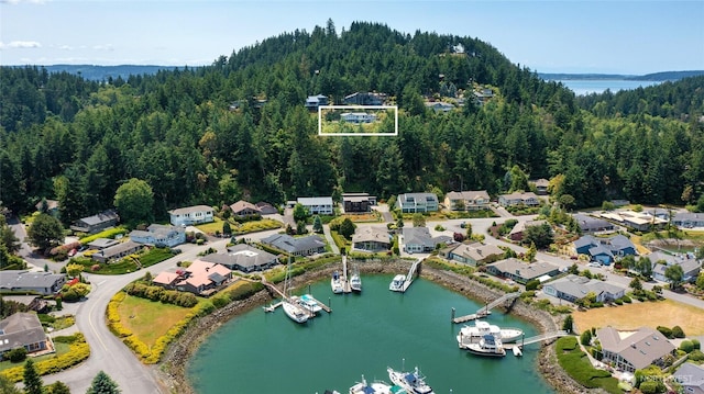 573 Klamath Dr, La Conner, WA 98257 - aerial overview of property's location featuring a heavily wooded area, a nearby body of water, property parcel outlined, and nearby suburban area