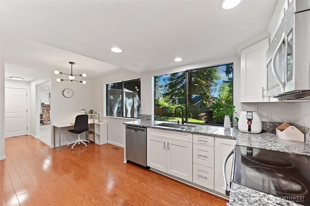 14208 93rd Ave NE, Kirkland, WA 98034 - kitchen featuring stainless steel appliances, a sink, light wood-style flooring, white cabinets, and light stone countertops