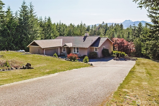 14903 Eagles View Dr, Seabeck, WA 98380 - single story home featuring asphalt driveway, a chimney, a wooded view, a garage, and a front yard