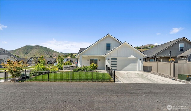 1007 Racine Springs Dr, Wenatchee, WA 98801 - modern farmhouse featuring board and batten siding, concrete driveway, a mountain view, a garage, and a residential view