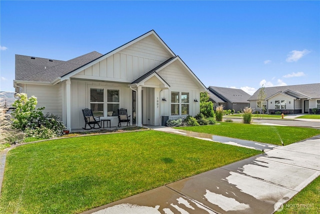 1007 Racine Springs Dr, Wenatchee, WA 98801 - modern inspired farmhouse featuring board and batten siding, a front yard, covered porch, and roof with shingles