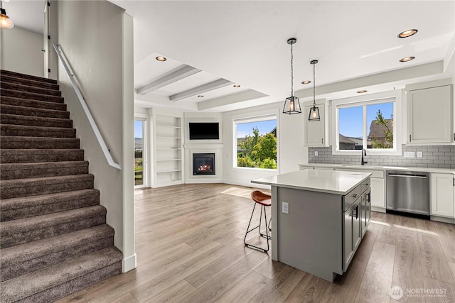 1007 Racine Springs Dr, Wenatchee, WA 98801 - kitchen featuring stainless steel dishwasher, open floor plan, a center island, light wood-style flooring, and decorative backsplash