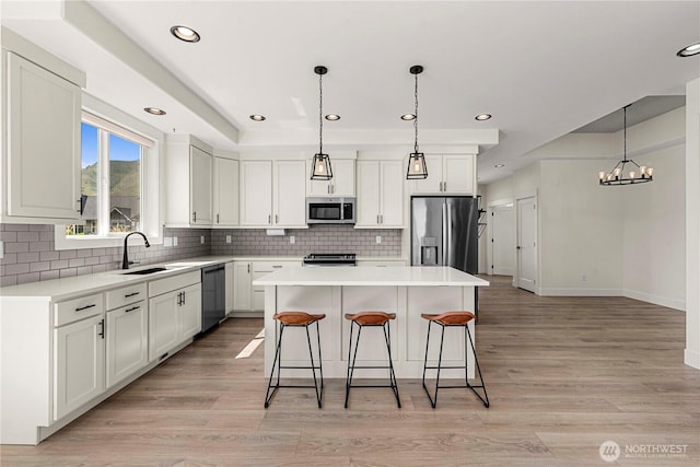 1007 Racine Springs Dr, Wenatchee, WA 98801 - kitchen with stainless steel appliances, a sink, a kitchen island, a kitchen bar, and decorative backsplash