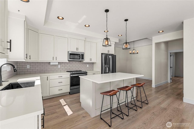 1007 Racine Springs Dr, Wenatchee, WA 98801 - kitchen featuring appliances with stainless steel finishes, a sink, a breakfast bar, recessed lighting, and decorative backsplash