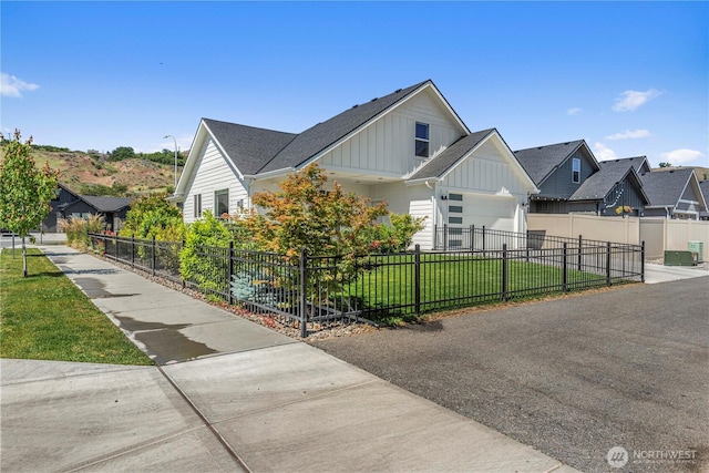 1007 Racine Springs Dr, Wenatchee, WA 98801 - view of front facade featuring board and batten siding, an attached garage, driveway, a residential view, and a shingled roof