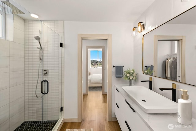 4306 S Holden St, Seattle, WA 98118 - full bathroom with wood finished floors, a shower stall, ensuite bath, vanity, and baseboards