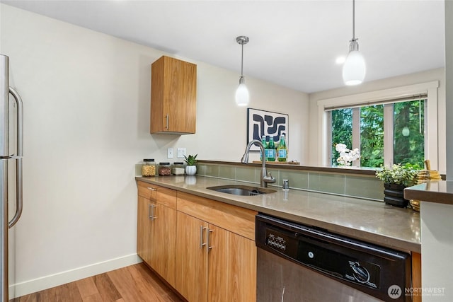 15155 NE 82nd St Unit 103, Redmond, WA 98052 - kitchen with a sink, dishwashing machine, freestanding refrigerator, light wood finished floors, and hanging light fixtures