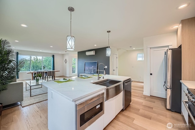 5930 18th Ave S, Seattle, WA 98108 - kitchen with stainless steel appliances, a sink, light wood-style flooring, recessed lighting, and decorative light fixtures