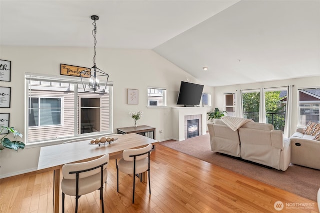 2143 Hammond Ave Unit E10, Dupont, WA 98327 - dining space with vaulted ceiling, a chandelier, light wood-style floors, a tile fireplace, and baseboards