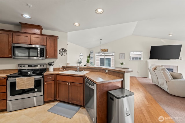2143 Hammond Ave Unit E10, Dupont, WA 98327 - kitchen featuring stainless steel appliances, a sink, a peninsula, open floor plan, and vaulted ceiling