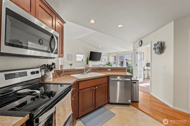 2143 Hammond Ave Unit E10, Dupont, WA 98327 - kitchen with appliances with stainless steel finishes, a peninsula, a sink, vaulted ceiling, and open floor plan