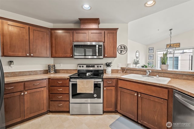 2143 Hammond Ave Unit E10, Dupont, WA 98327 - kitchen with stainless steel appliances, a sink, recessed lighting, brown cabinetry, and vaulted ceiling