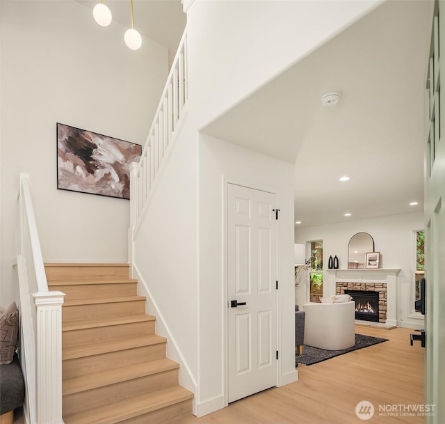 16302 NE 104th St, Redmond, WA 98052 - staircase featuring wood finished floors, a stone fireplace, and recessed lighting