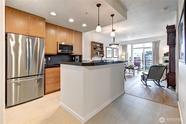 16141 Cleveland St Unit 611, Redmond, WA 98052 - kitchen with stainless steel appliances, dark countertops, light tile patterned flooring, recessed lighting, and hanging light fixtures