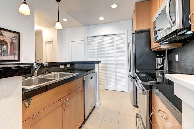 16141 Cleveland St Unit 611, Redmond, WA 98052 - kitchen featuring stainless steel appliances, a sink, dark countertops, light tile patterned floors, and hanging light fixtures