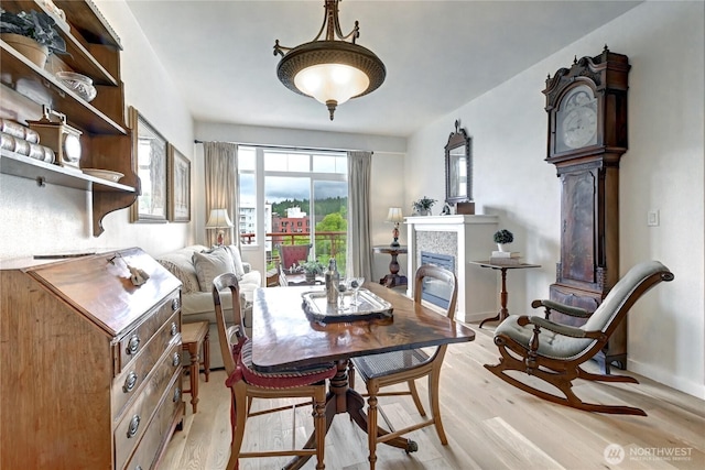 16141 Cleveland St Unit 611, Redmond, WA 98052 - dining area with light wood-style flooring and a tiled fireplace