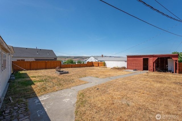 614 E Main Ave, Soap Lake, WA 98851 - fenced backyard with an outdoor fire pit and an outdoor structure