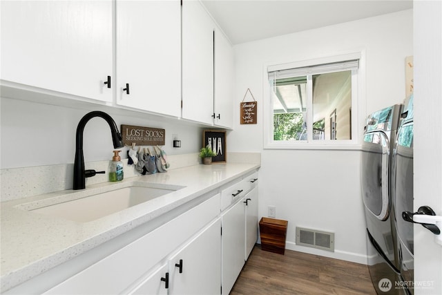 3827 90th Ave E, Edgewood, WA 98371 - laundry room featuring washer and dryer, cabinet space, baseboards, and dark wood-style flooring