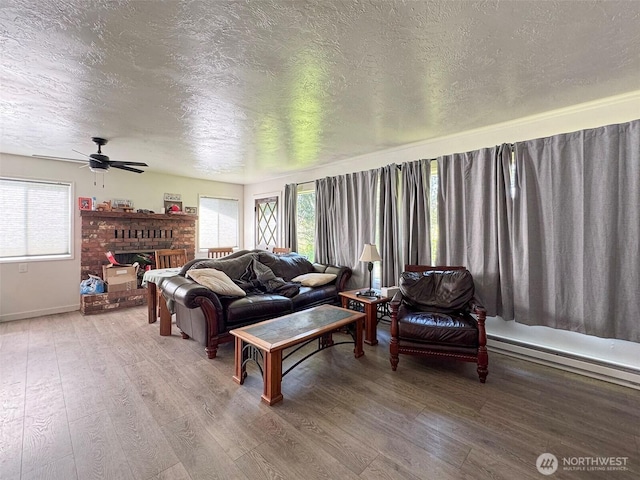 81 Robbins Rd, Sequim, WA 98382 - living area featuring wood finished floors, a textured ceiling, healthy amount of natural light, and a fireplace