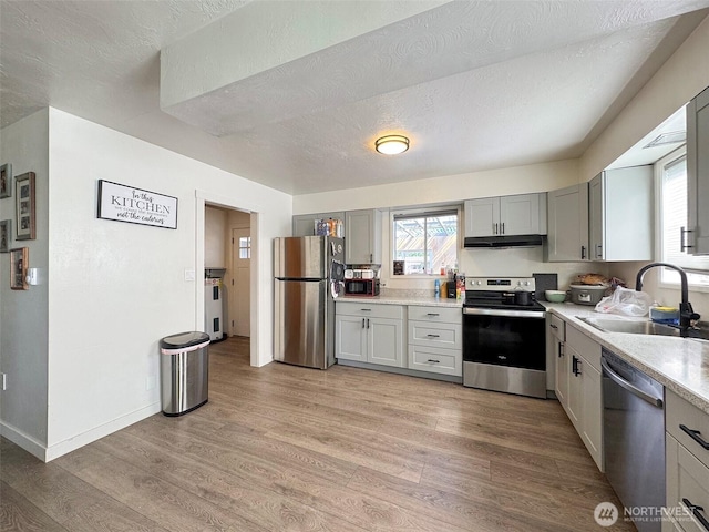 81 Robbins Rd, Sequim, WA 98382 - kitchen featuring appliances with stainless steel finishes, a sink, light countertops, under cabinet range hood, and a textured ceiling
